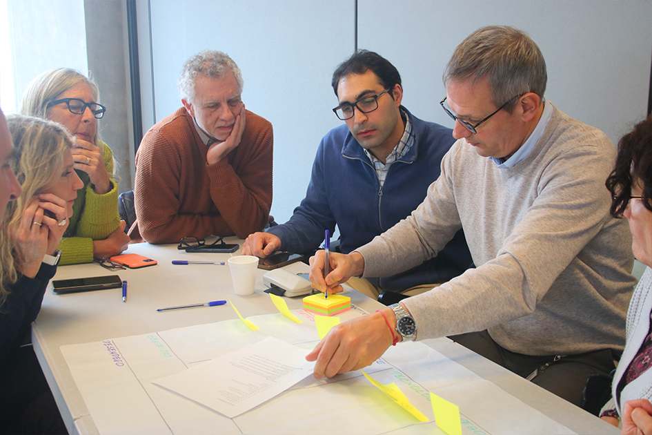 Encuentros de tecnologías de la información Personas en las mesas de trabajo participando del Encuentro de TI escribiendo en un papelógrafo
