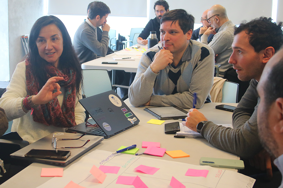 Encuentros de tecnologías de la información Personas en las mesas de trabajo participando del Encuentro de TI discutiendo un tema