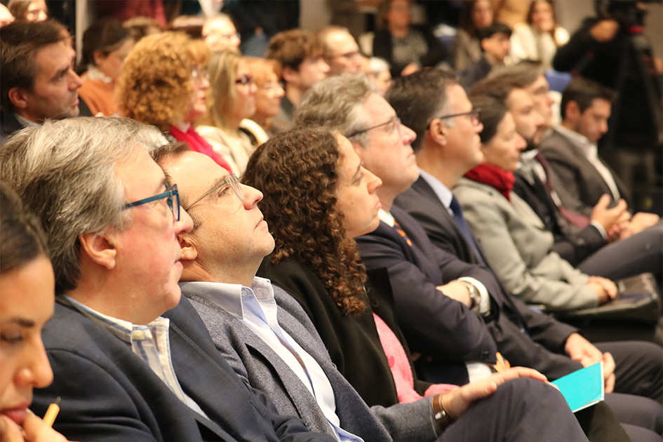 Integrantes del panel de autoridades Autoridades sentados en la sala prestando atención a los expositores