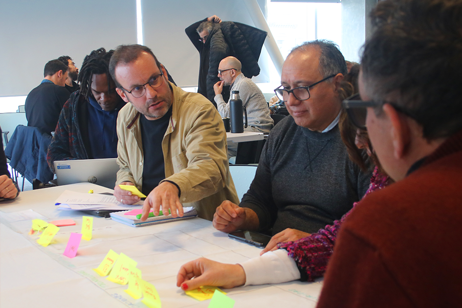 Encuentros de tecnologías de la información Personas en las mesas de trabajo participando del Encuentro de TI manteniendo una conversación