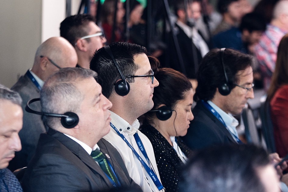 Simposio de Ciberseguridad  Personas con dispositivo de traducción escuchando la presentación