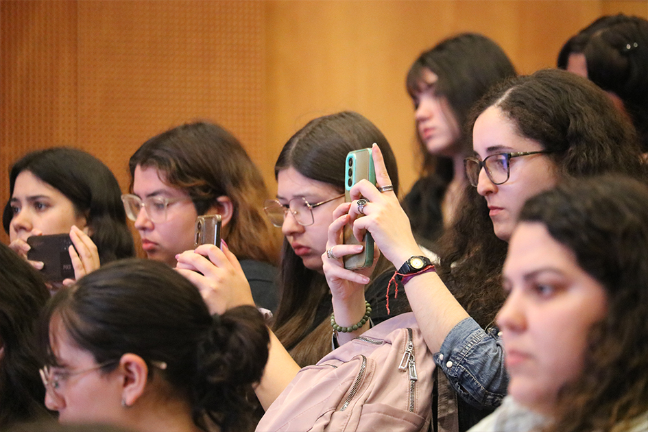Feria de Mentorías en Ciberseguridad. Personas en sala tomando fotografías de los paneles de la Feria de Mentorías.