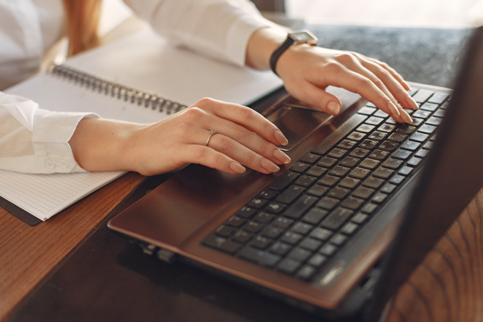 Una persona escribiendo en el teclado una computadora Una persona escribiendo en el teclado una computadora