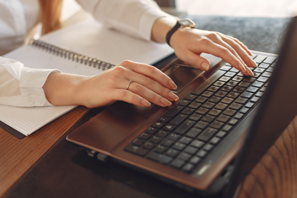 Una persona escribiendo en el teclado una computadora