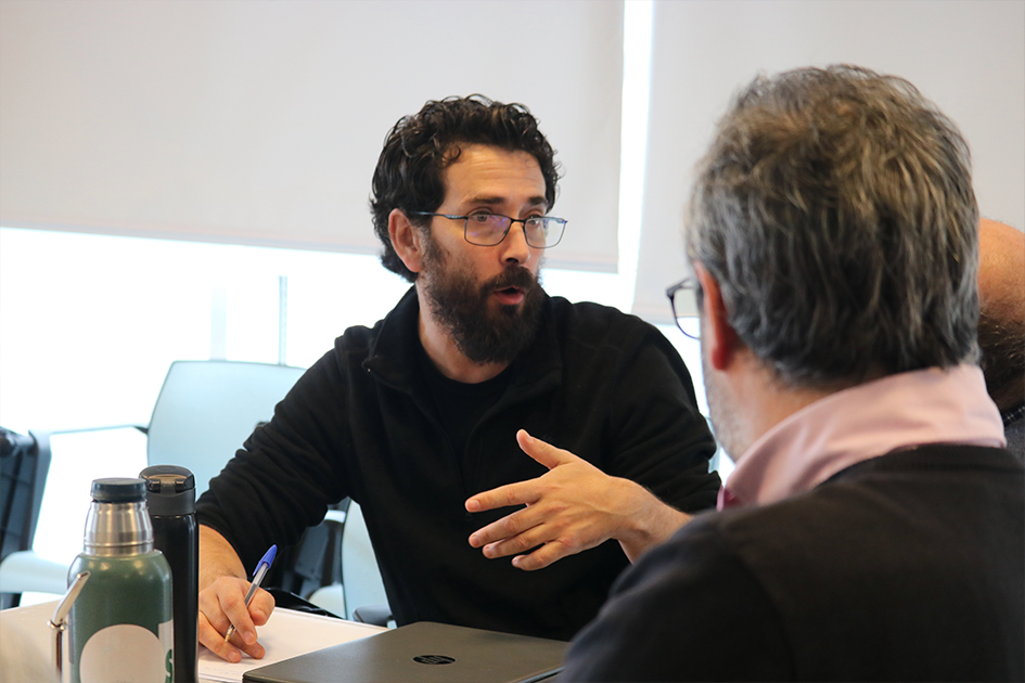 Encuentros de tecnologías de la información Personas en las mesas de trabajo participando del Encuentro de TI expresando una idea