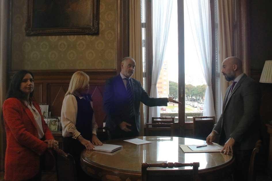 Victoria Vera, Beatriz Argimón, Gustavo Sánchez Piñeiro, Hebert Paguas Autoridades de pie alrededor de una mesa intercambiando ideas sobre el informe