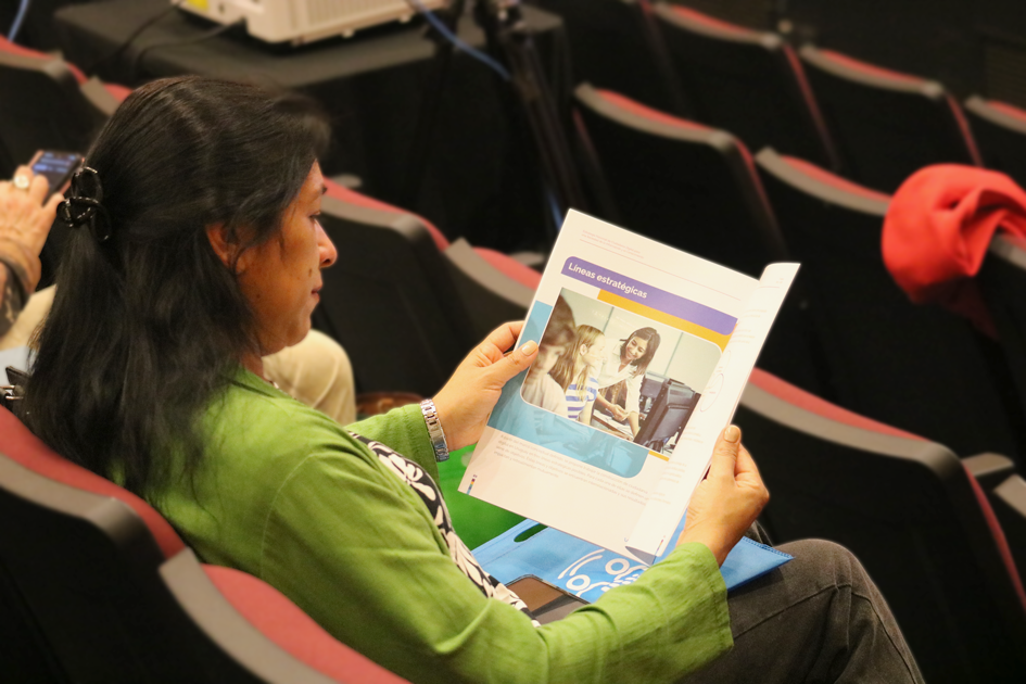 Una mujer en la sala leyendo la Guía