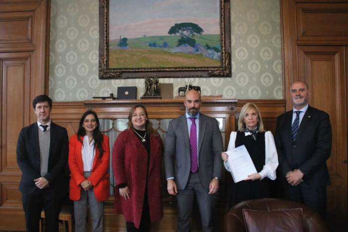 Autoridades de pie mostrando el informe firmado sobre recomendaciones para una regulación de la IA