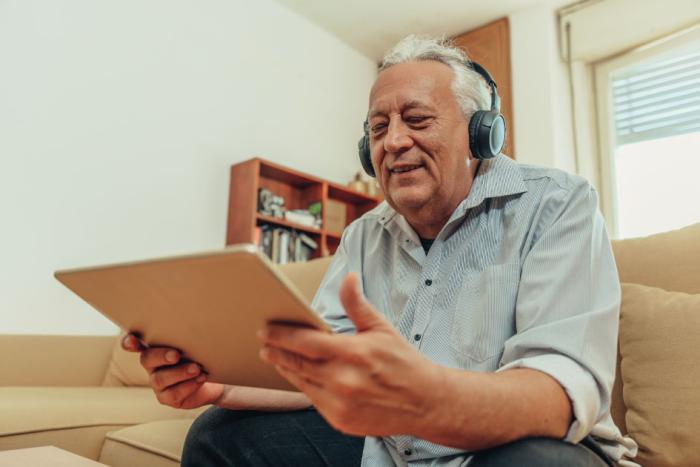 Convertir texto en audio: nueva herramienta para páginas web Persona utilizando auriculares para escuchar el contenido de un dispositivo