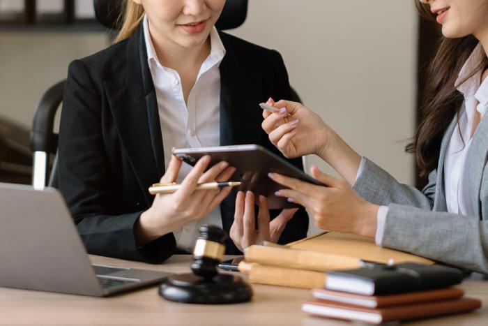 Sistema de Gestión de Apoderados Dos mujeres utilizando un celular mientras conversan