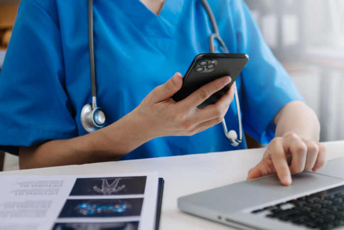 Personal de la salud utilizando un celular y computadora. Personal de la salud utilizando un celular y computadora.