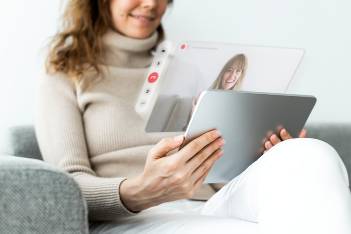 Persona con una tablet durante una videollamada Persona con una tablet durante una videollamada