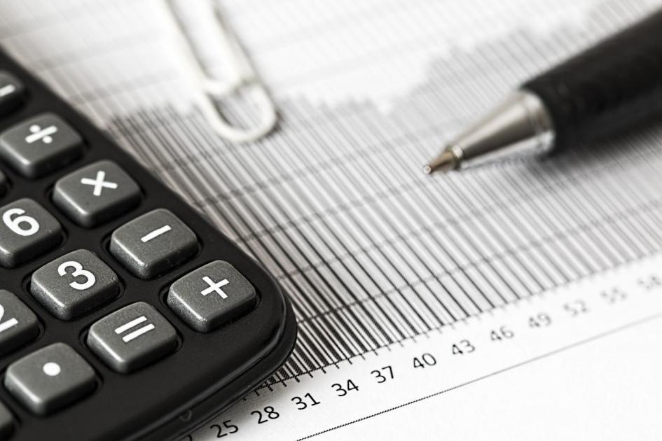 Montos 2020 Calculadora, clip y lapicera sobre papel con estadísticas