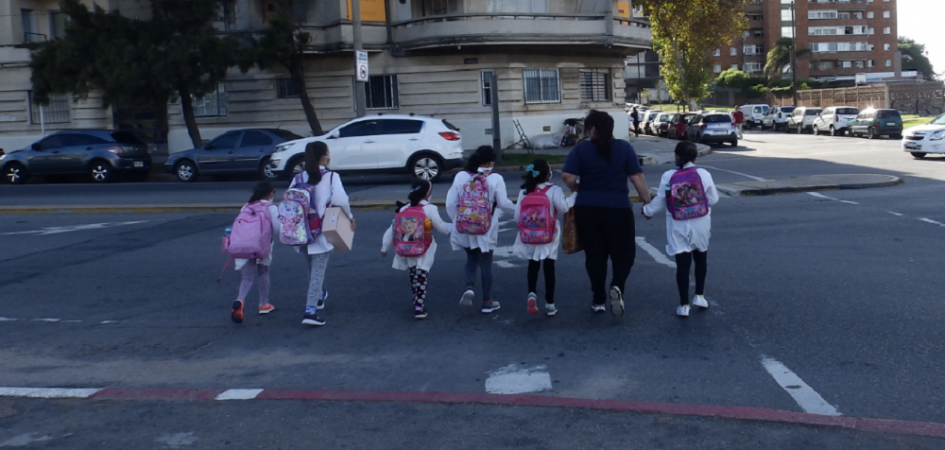Madres cruzando la calle con niños escolares Madres cruzando la calle con niños escolares