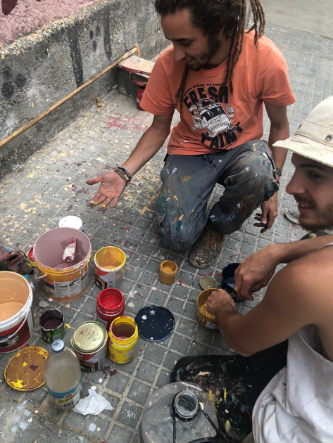 Mural cooperación Iberoaméricana artistas en la vereda en el momento de realizar el mural