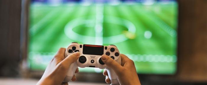 persona frente a televisor sosteniendo comando para uso de videojuego