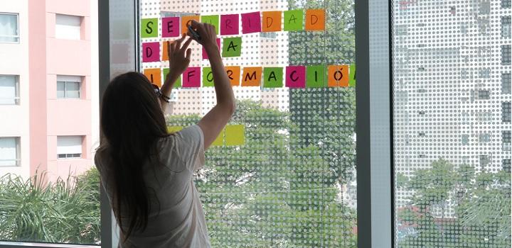 Imagen de una chica pegando post it de Seguridad de la Información Imagen de una chica pegando post it de Seguridad de la Información