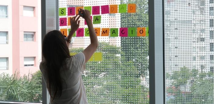 Imagen de una chica pegando post it de Seguridad de la Información