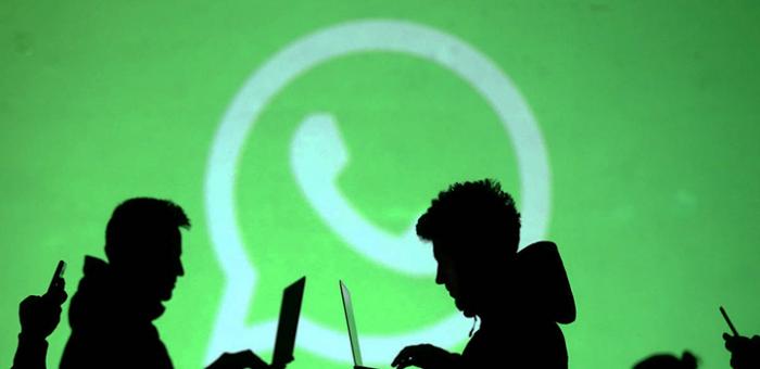 personas en la sombra con computadoras y fondo de logo whatsapp