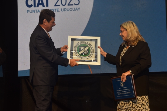 Margarita Faral recibiendo una placa reconocimiento del CIAT de manos de Marcio Verdi
