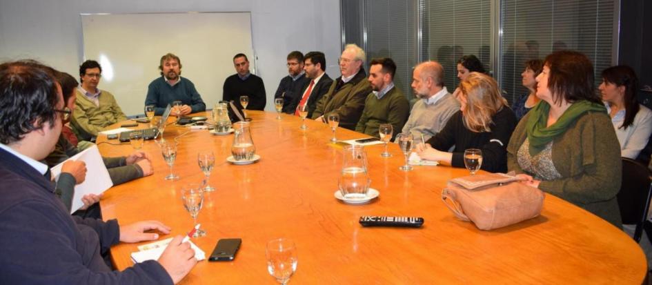 Reunión de intercambio se observa mesa redonda con distintos participantes de organismos estatales alrededor.