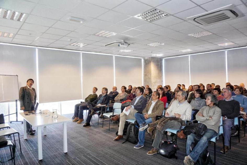Capacitación INEGI capacitación salón con auditorio lleno, experto mexicano explica parado a los participantes.
