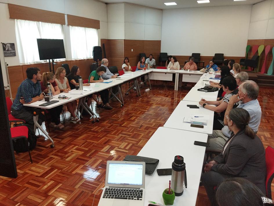 Grupo de trabajo reunido en torno a una mesa dispuesta en U