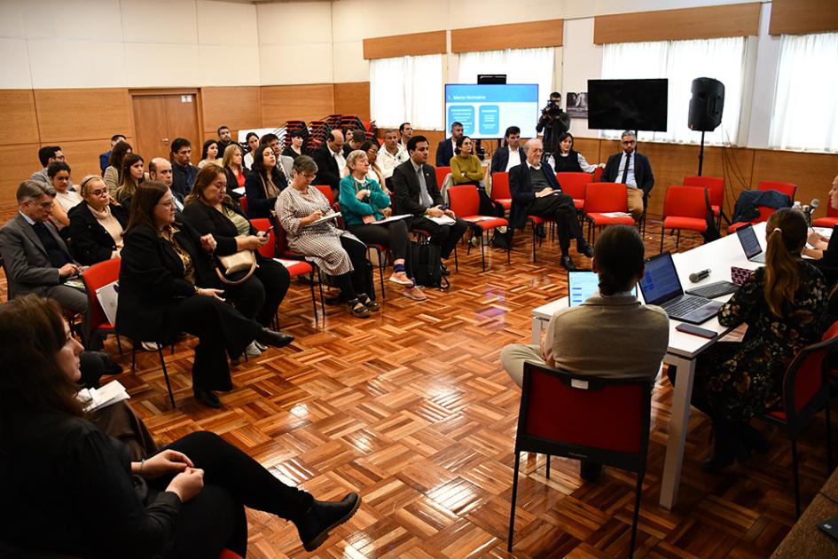 Quinta mesa de trabajo de la Unidad de Migrantes de la INDDHH Público asistente a la mesa de trabajo escuchando la presentación del informe