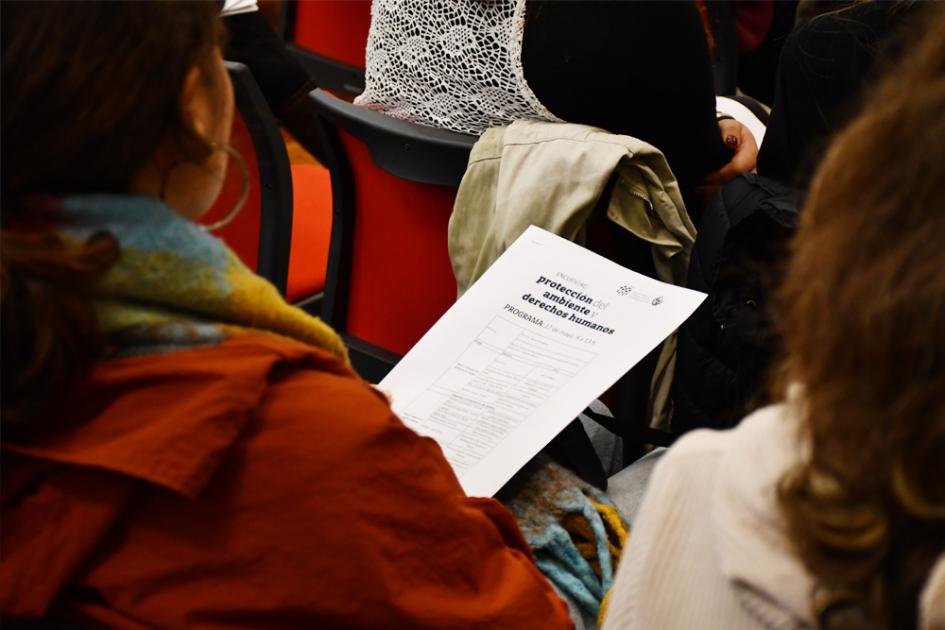 Encuentro Protección del Ambiente Un participante tiene un programa del encuentro en la mano