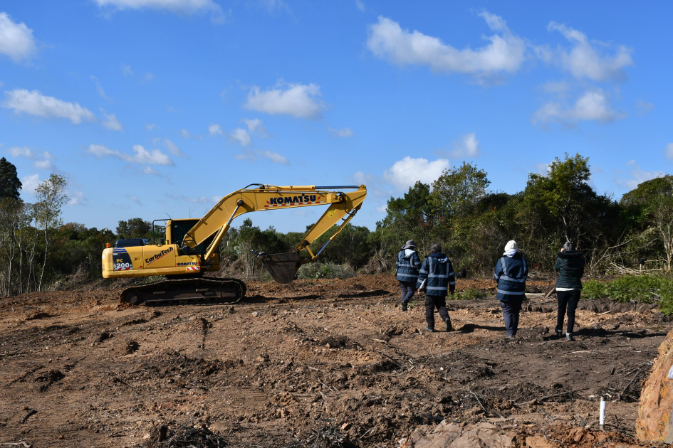 Equipo en el terreno, con la retroexcavadora Equipo en el terreno, con la retroexcavadora