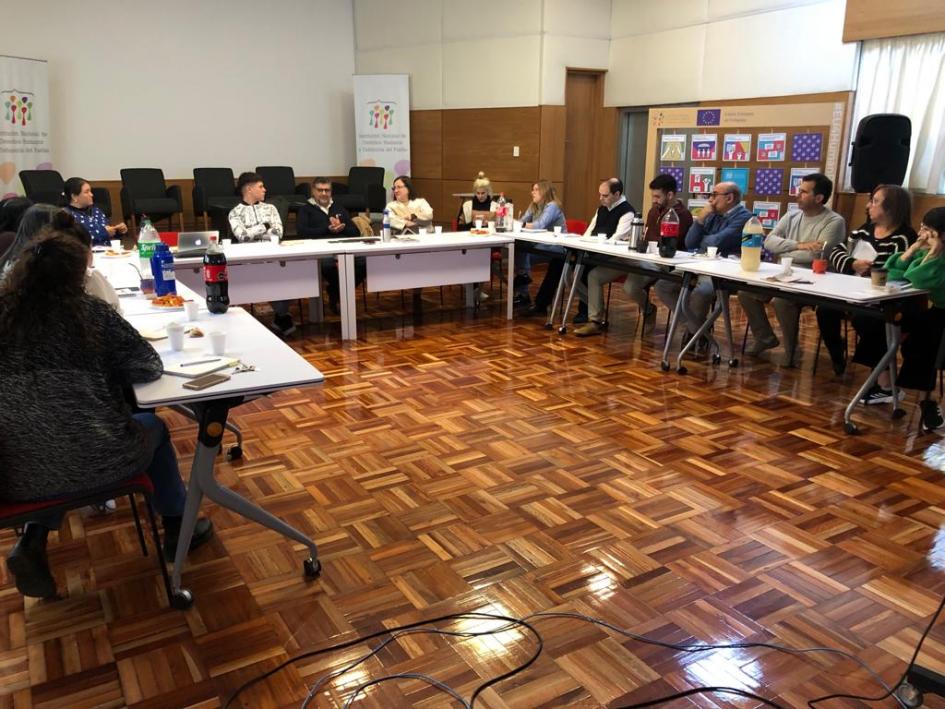 Foto capacitación interna sobre la nueva conceptualización de la discapacidad Integrantes de la Institución sentados en torno a una mesa intercambian durante el taller.