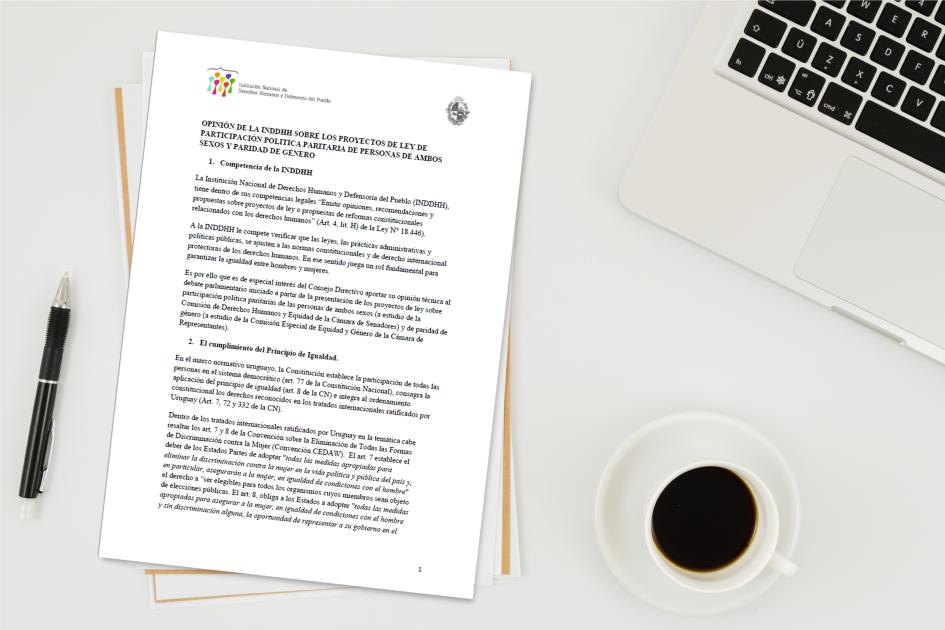 Imagen ilustrativa se ve el informe impreso sobre una mesa con una lapicera, un café y una computadora a los lados