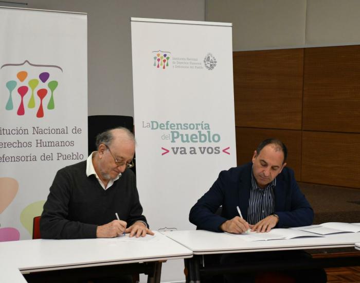 Marcos Israel, presidente INDDHH y Juan Pedro López, alcalde Municipio F firman convenio