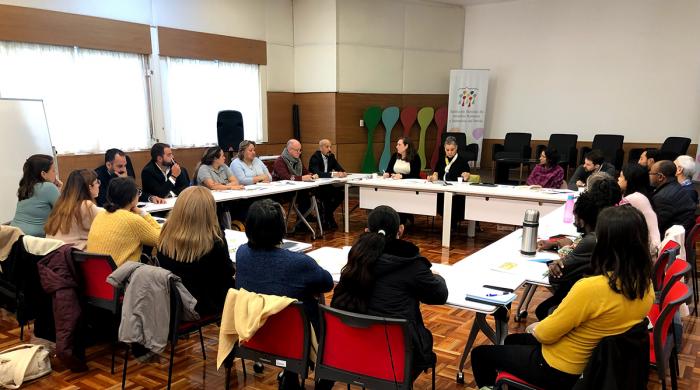 Se ve el grupo de trabajo reunido en torno a una mesa