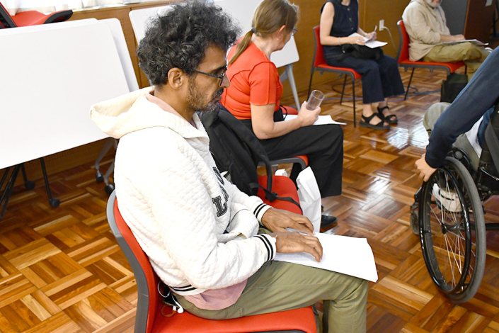 Participante leyendo el reglamento del Consejo Asesor en braille Participante leyendo el reglamento del Consejo Asesor en braille