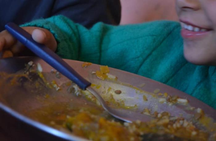 Niño almorzando un plato caliente