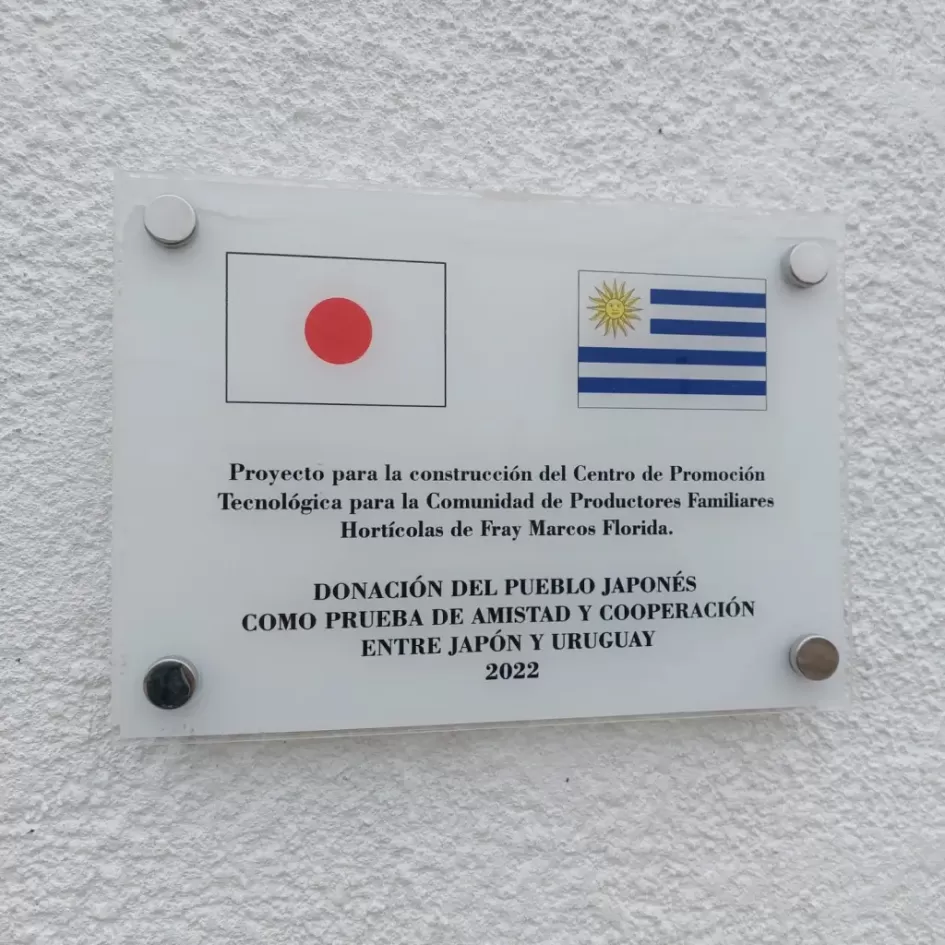 Placa conmemorativa Placa en pared del establecimiento banderas de Uruguay y japón en ocasión de la donación realizada