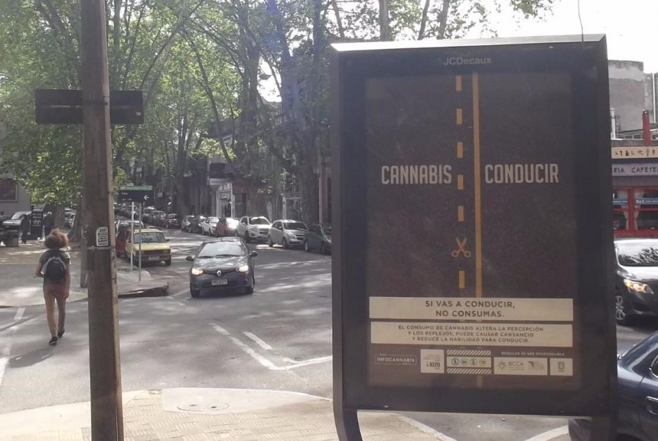 Afiche en vía pública con una ruta cortada con la línea amarilla de no pasar y el mensaje si vas a conducir no consumas
