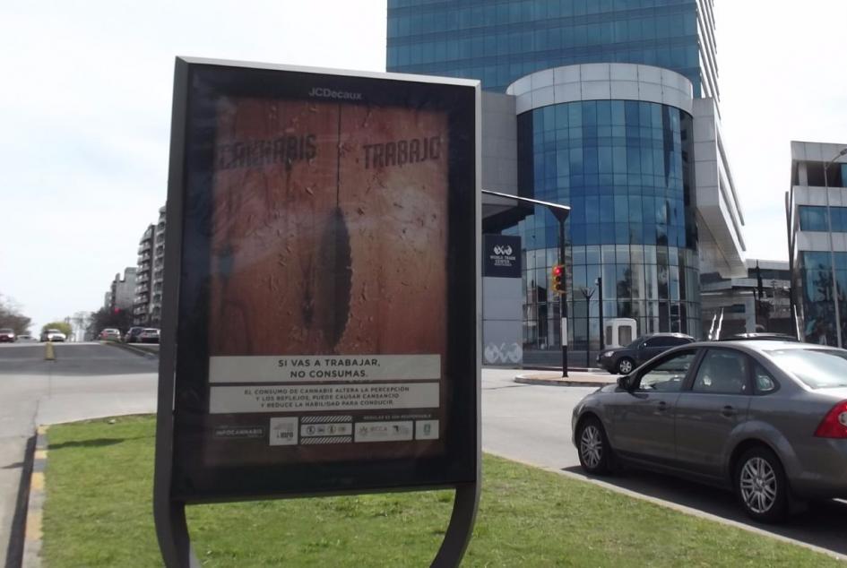 Afiche cannabis/trabajo Afiche en vía públia con una sierra circular cortando una madera que de un lado dice cannabis y del otro trabajo con el mensaje si vas a trabajar no consumas