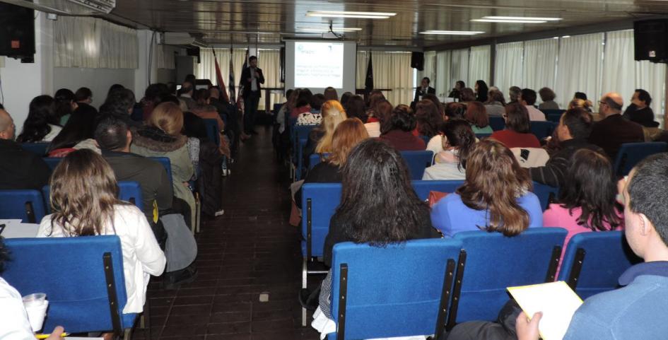 Exposición de Diego Olivera Vista del público desde atrás que está escuchando la exposición de Diego Olivera