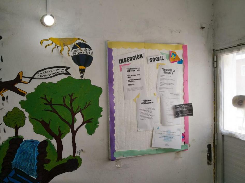 Pizarra de mensajes Pizarra con mensajes colgada en la pared al lado de un grafitti