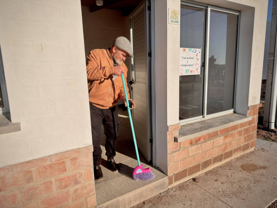 Vecino barriendo su vivienda recién inaugurada Vecino barriendo su vivienda recién inaugurada