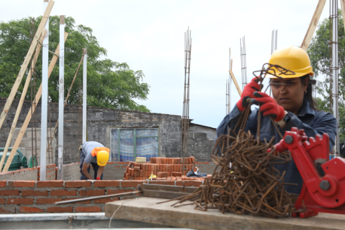 Mujer construyendo su vivienda