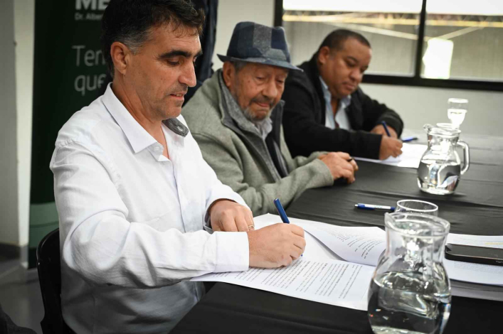 Presidente Lima junto al director firmando el convenio