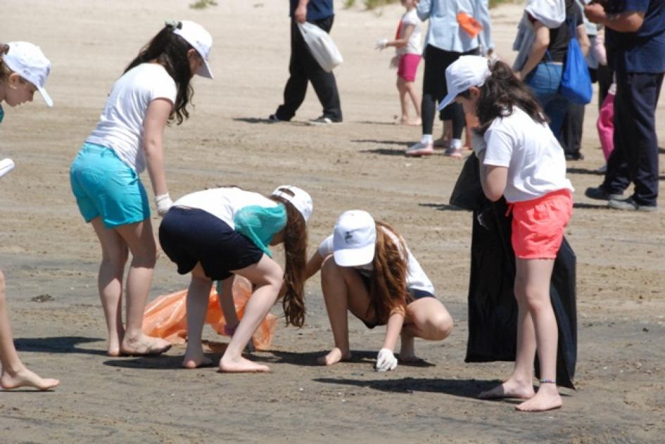 Niños voluntarios de la limpieza de costa limpian la playa