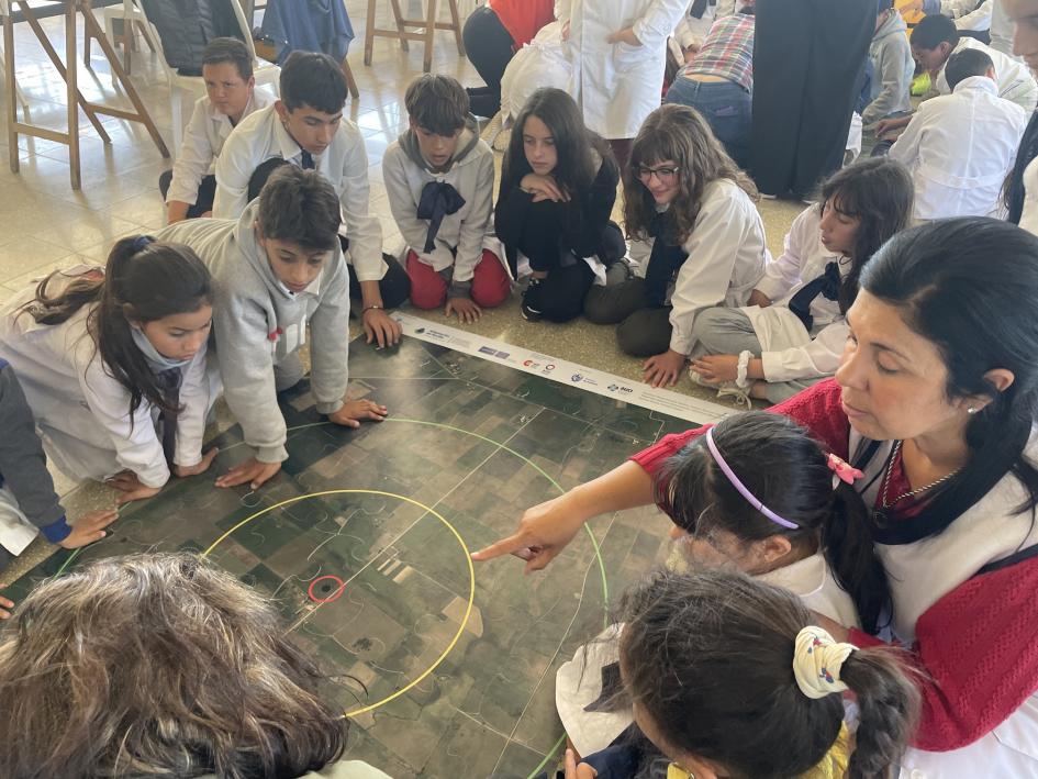 La directora y los alumnos de la Escuela rural N° 58 armando el puzzle en el taller.