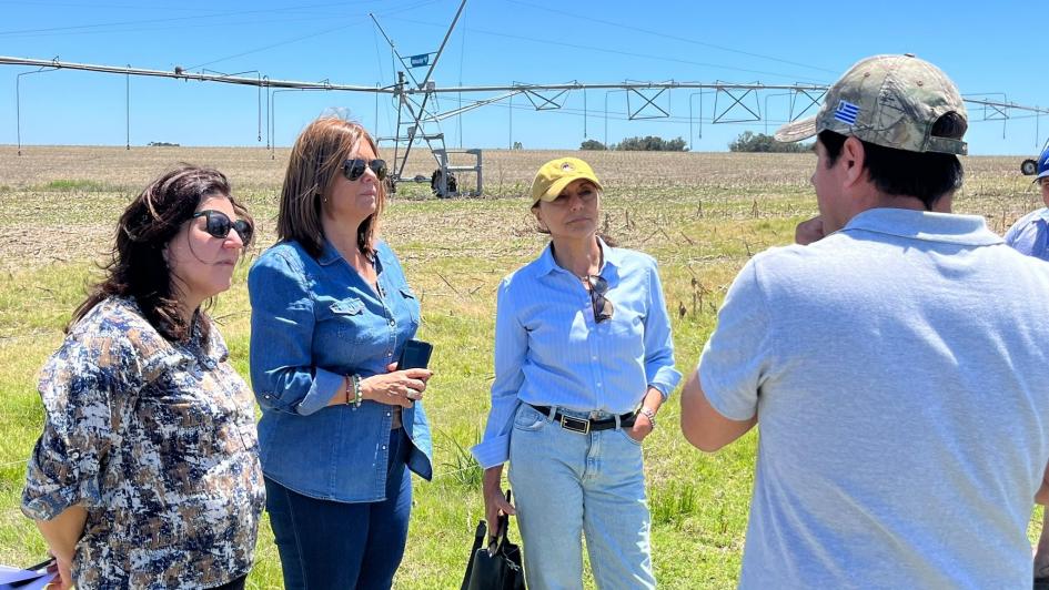 Directora Nacional de Aguas, Arq. Viviana Pesce y otros integrantes. En el fondo un sistema de riego