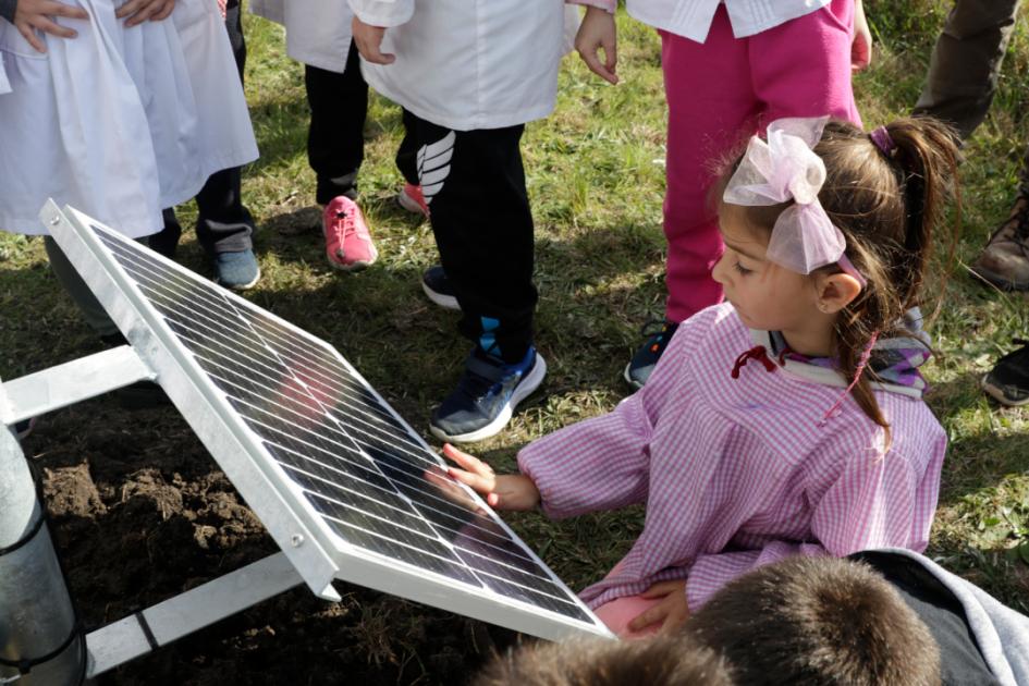 Una alumna de cuatro años observa el panel solar del dispositivo