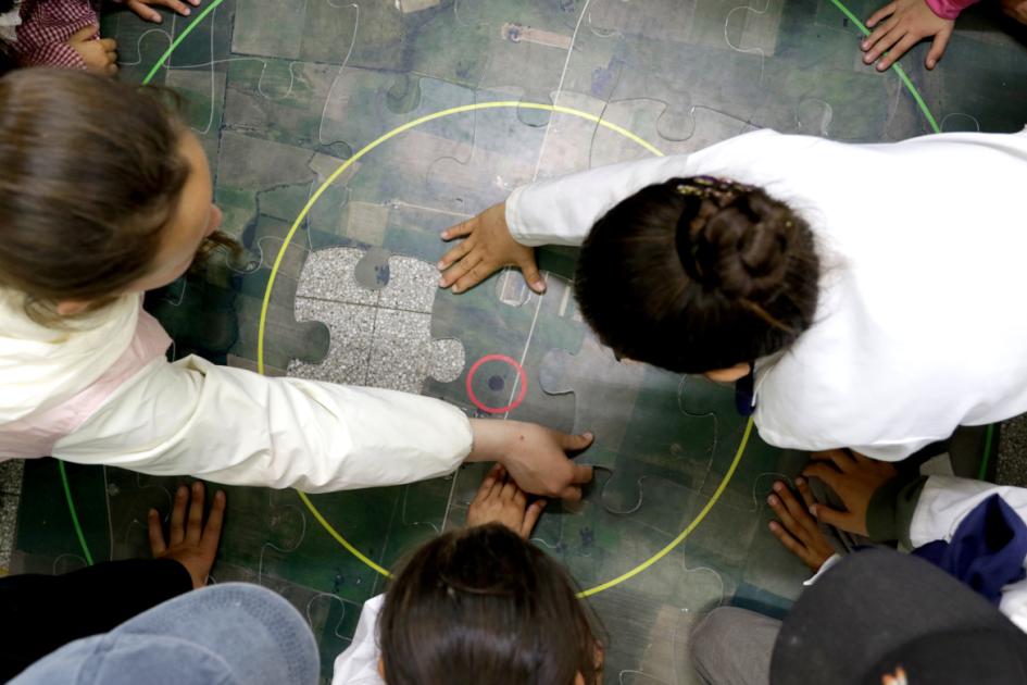 Niños armando el puzzle del los perímetros de protección de pozos