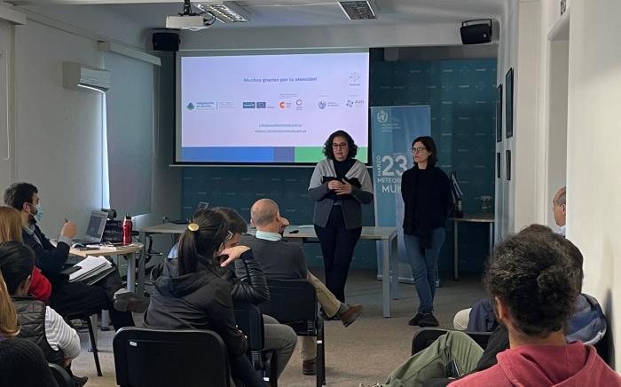 Dos técnicas de Dinagua e Inumet presentando los avances del proyecto ante el público en Inumet.